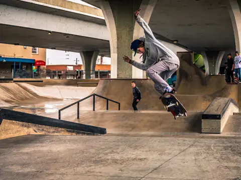 A skateboarder mid-air over a plaza, seen from below